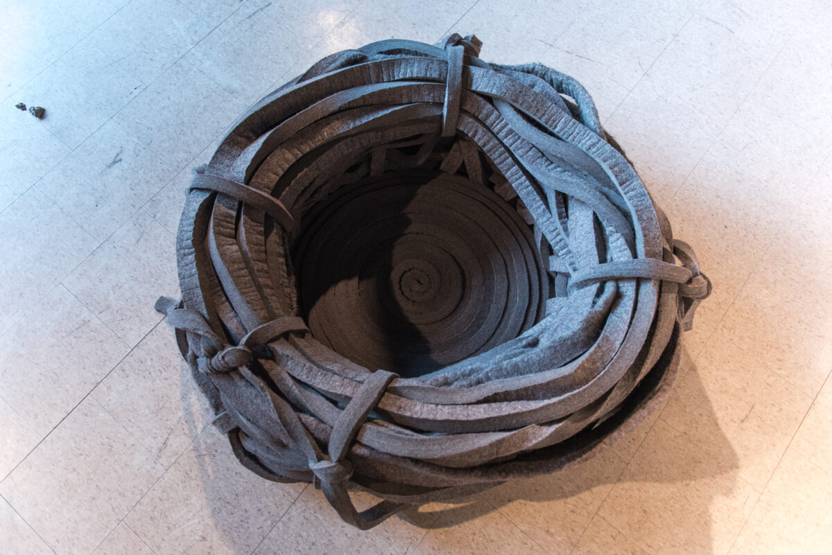A nest-like textile installation sitting on the floor.