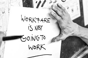 A black and white photo of a piece of paper that reads Workfare is Not Going to Work.