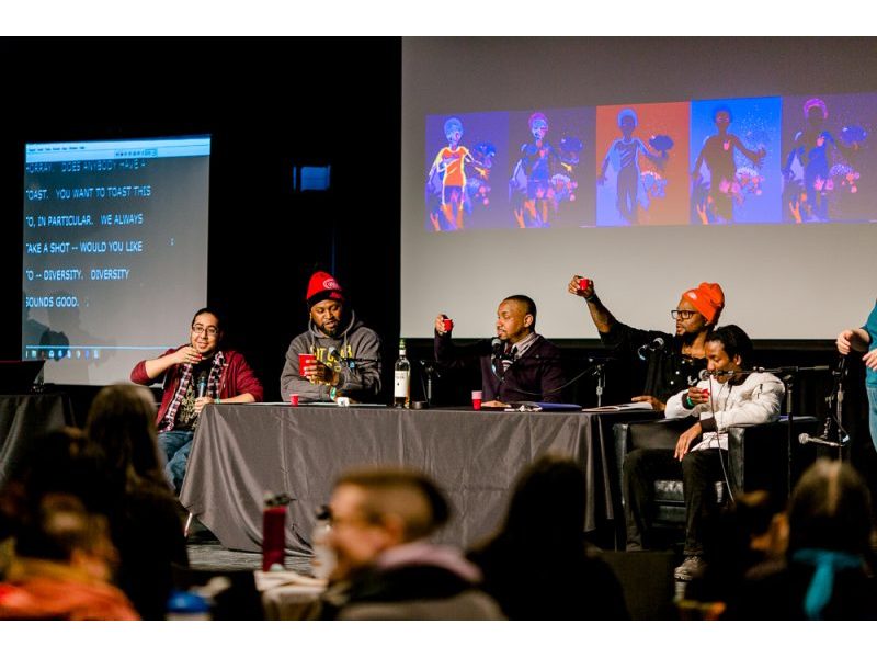 A panel discussion with five people holding up shot glasses on a stage.