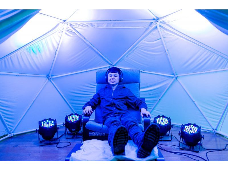Young person sitting in a chair inside a dome.