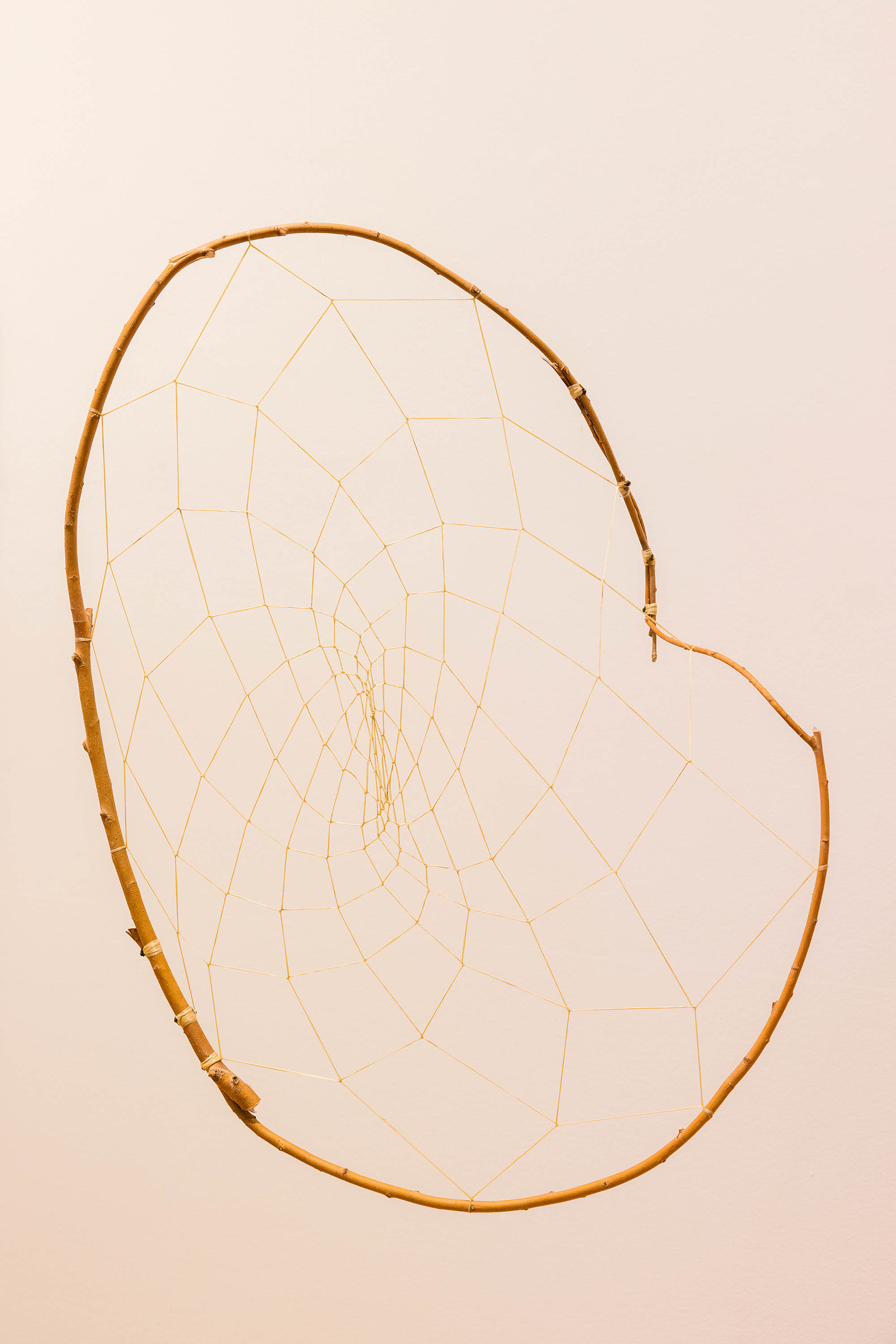 An irregularly-shaped dreamcatcher made from willow branches.
