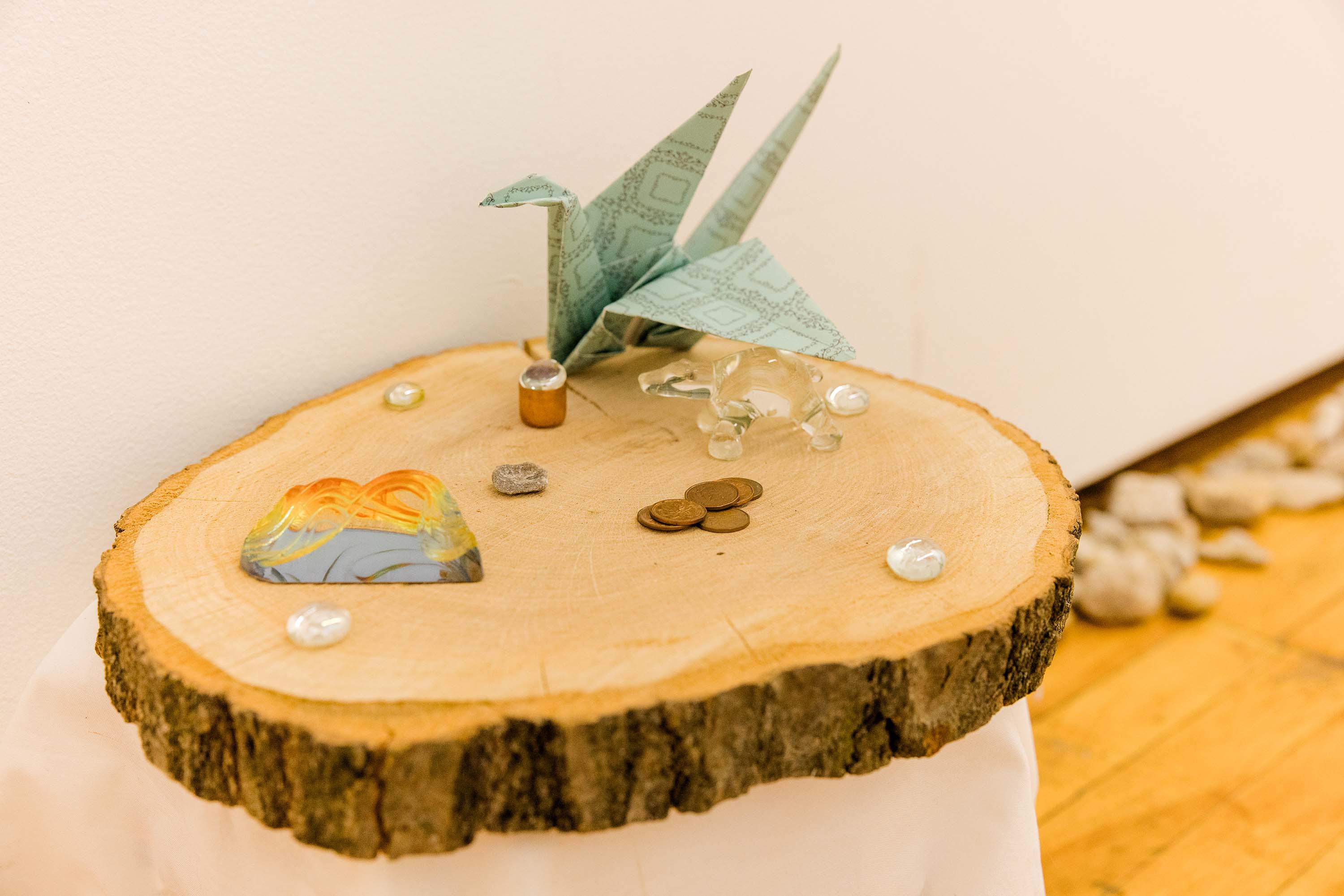 A round piece of wood displaying small objects including a paper crane and a glass polar bear.