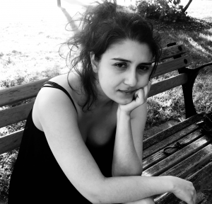 A black and white photo of Rana sitting on a park bench
